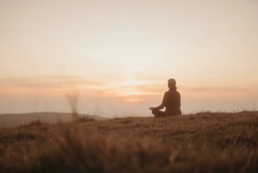 Persona en meditación silenciosa al amanecer, introducción al Kriya Yoga